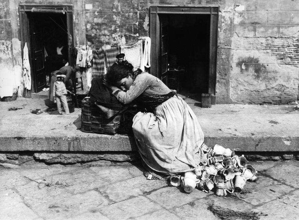 Una ragazza che vende tazzine e altri oggetti di ceramica si riposa in una strada di Napoli, verso il 1885. (ANSA ALINARI)